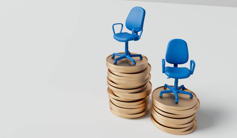 2 blue office chairs, each on a stack of coins.