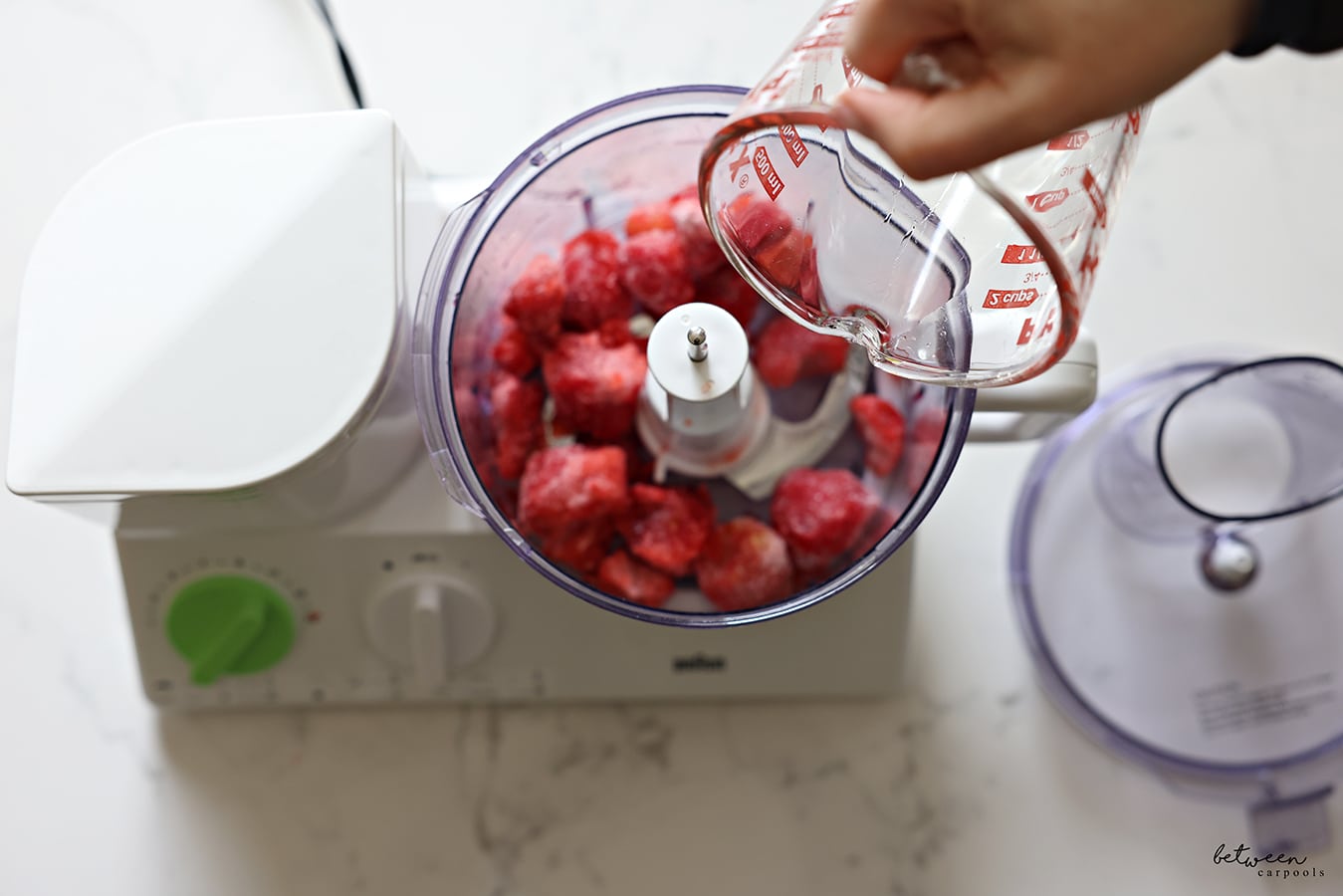 frozen strawberries in the bowl of a food processor