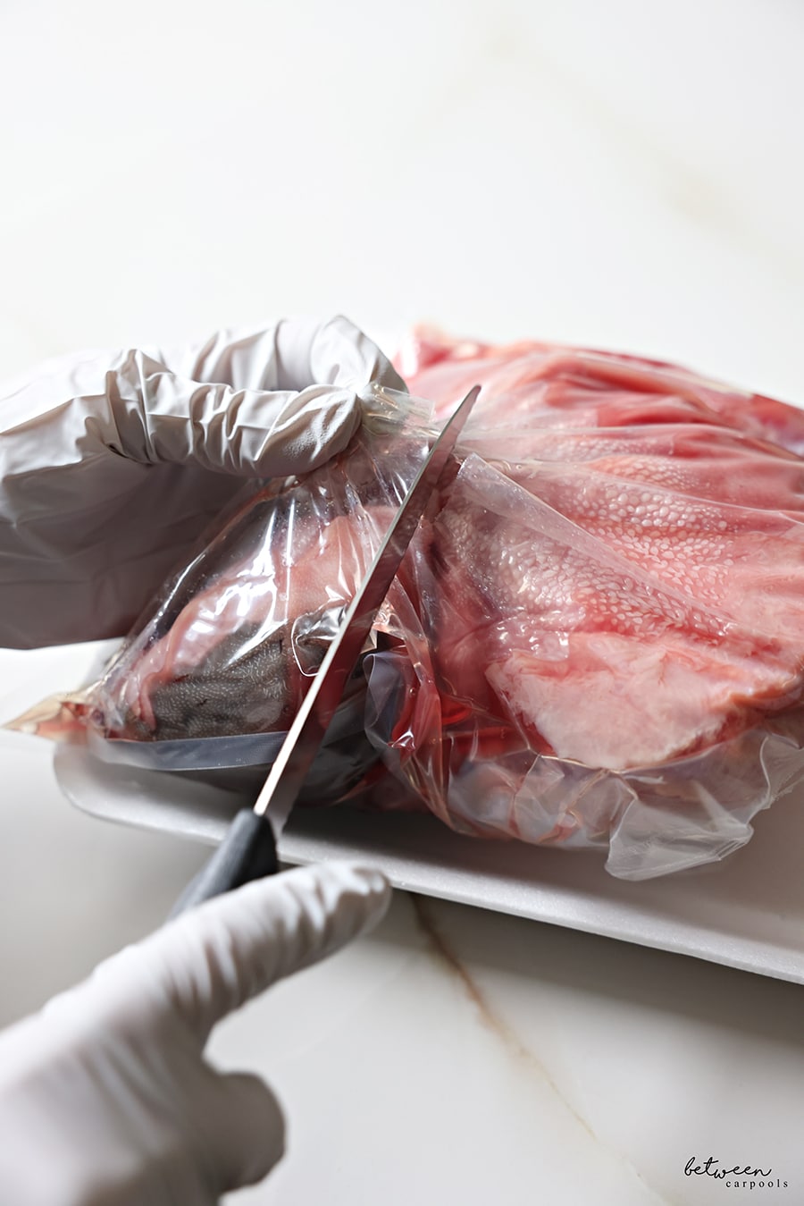 removing tongue from vacuum pack. cutting into the vacuum seal with a knife