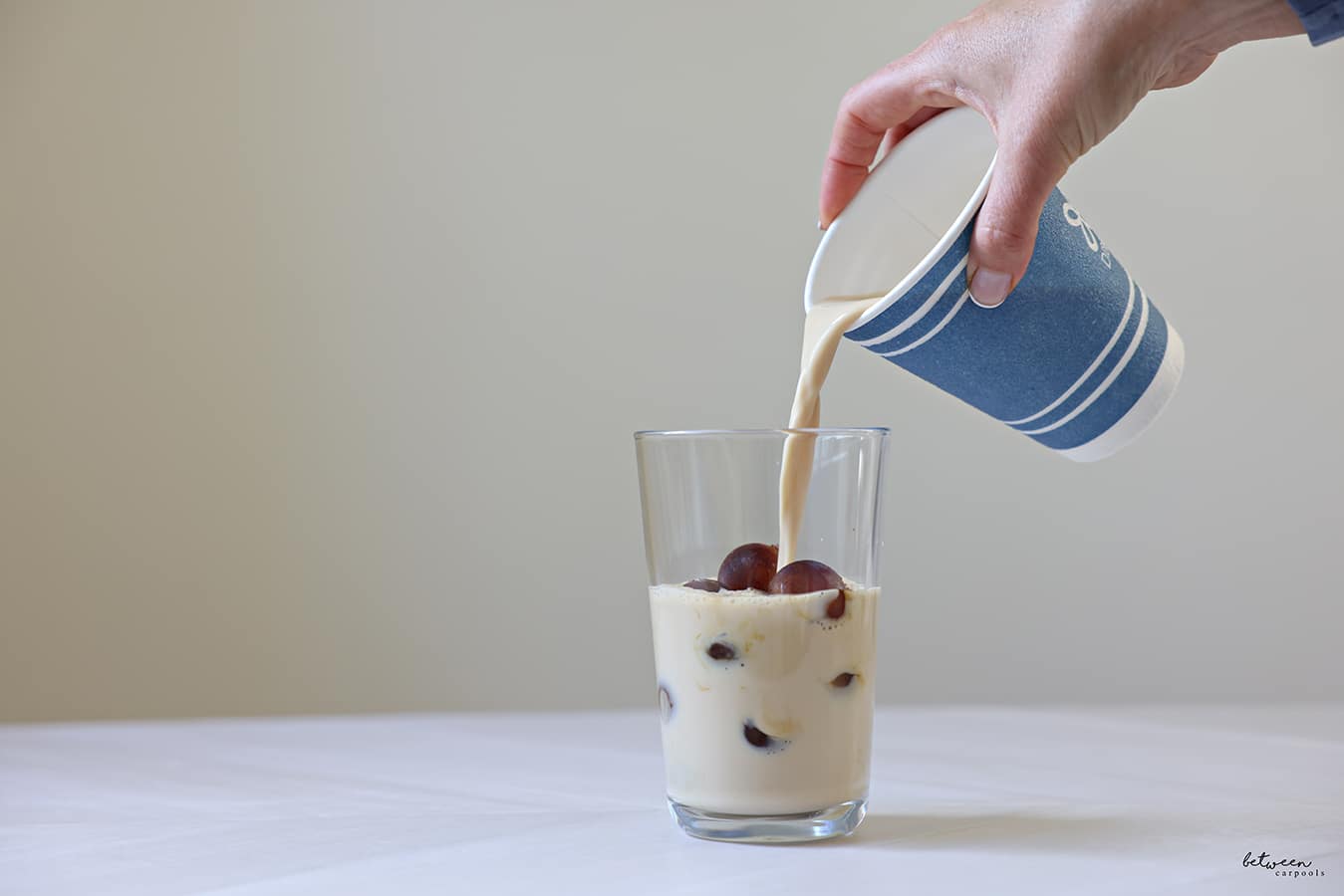 Pouring milk into a glass with brewed coffee Ice Balls