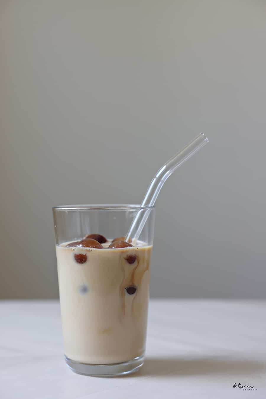 milk in a glass + a straw with brewed coffee Ice Balls