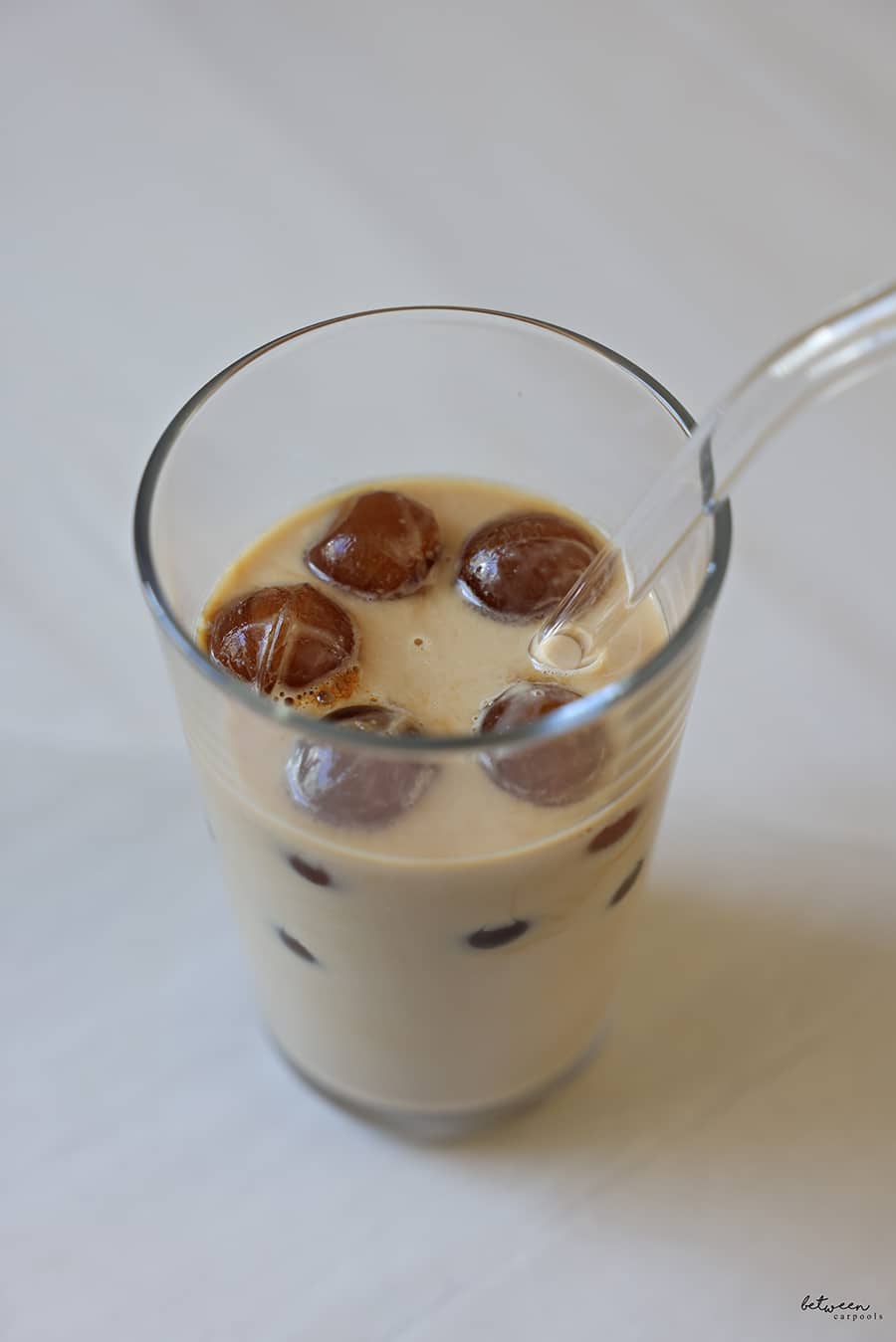 milk in a glass + a straw with brewed coffee Ice Balls