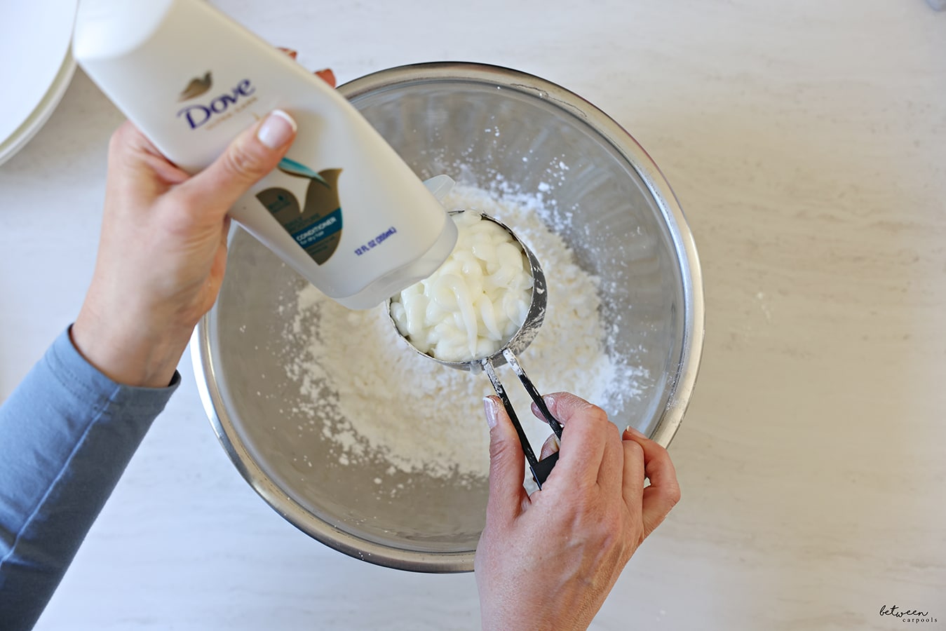 Adding conditioner to corn starch in a metal mixing bowl