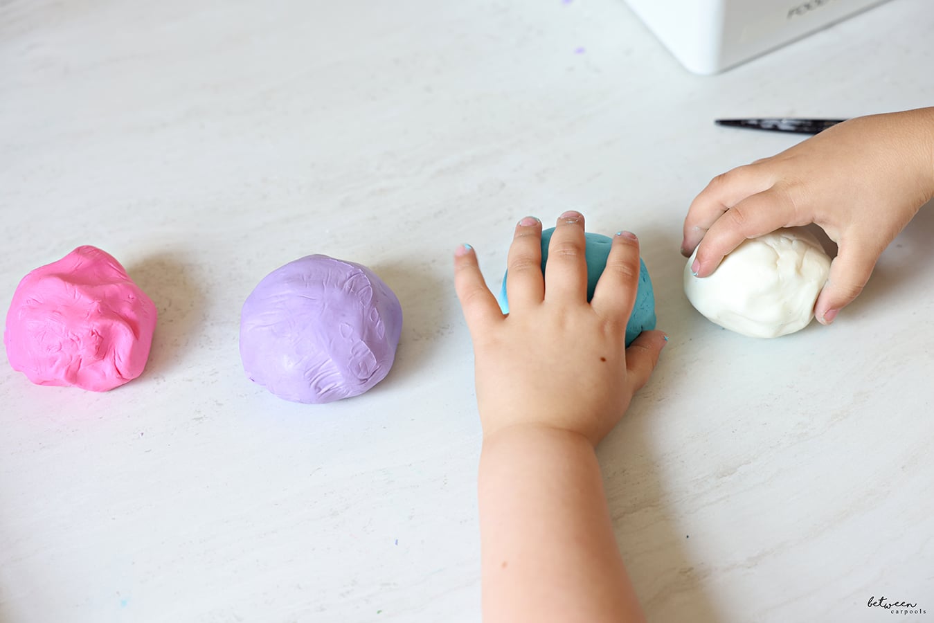 Colored - pink, purple, green, and white - balls of homemade Play-Doh