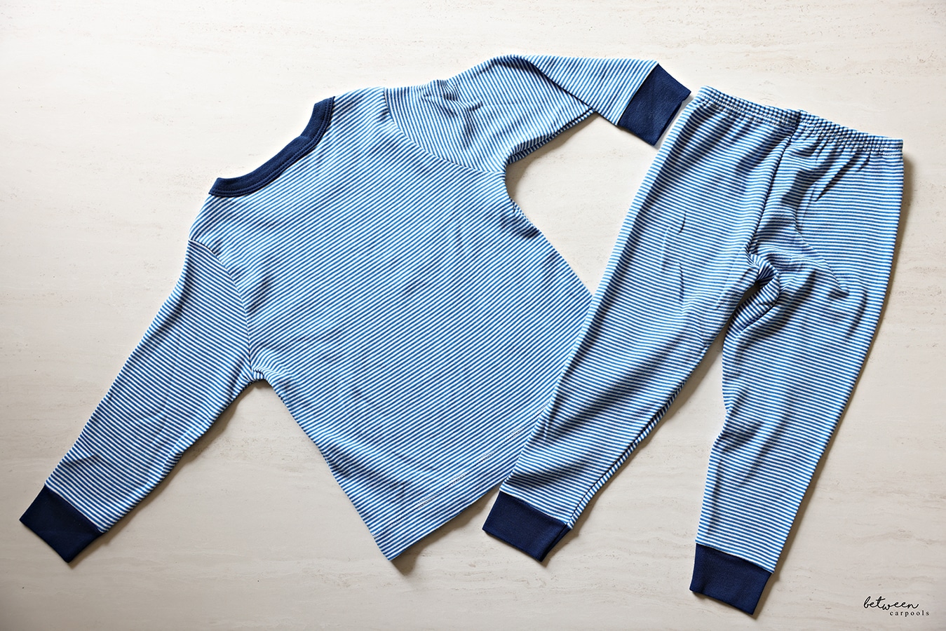 Pajama top and bottom laying flat on a flat surface.
