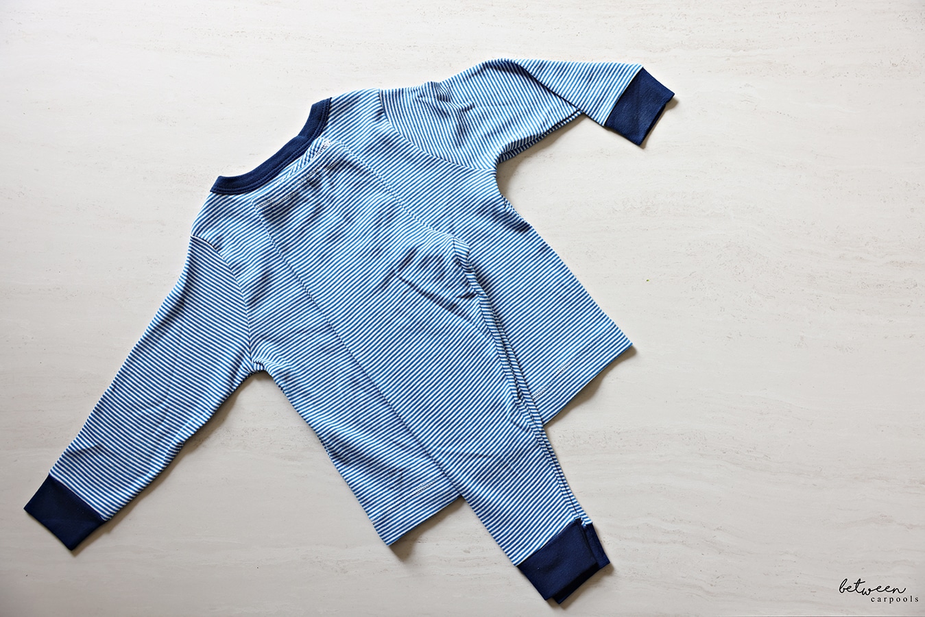 The folded in half pajama pants placed in the middle of the pajama shirt.