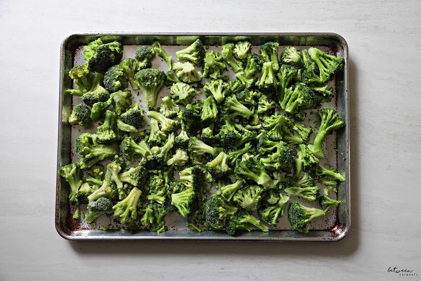 frozen broccoli florets on a metal sheet pan