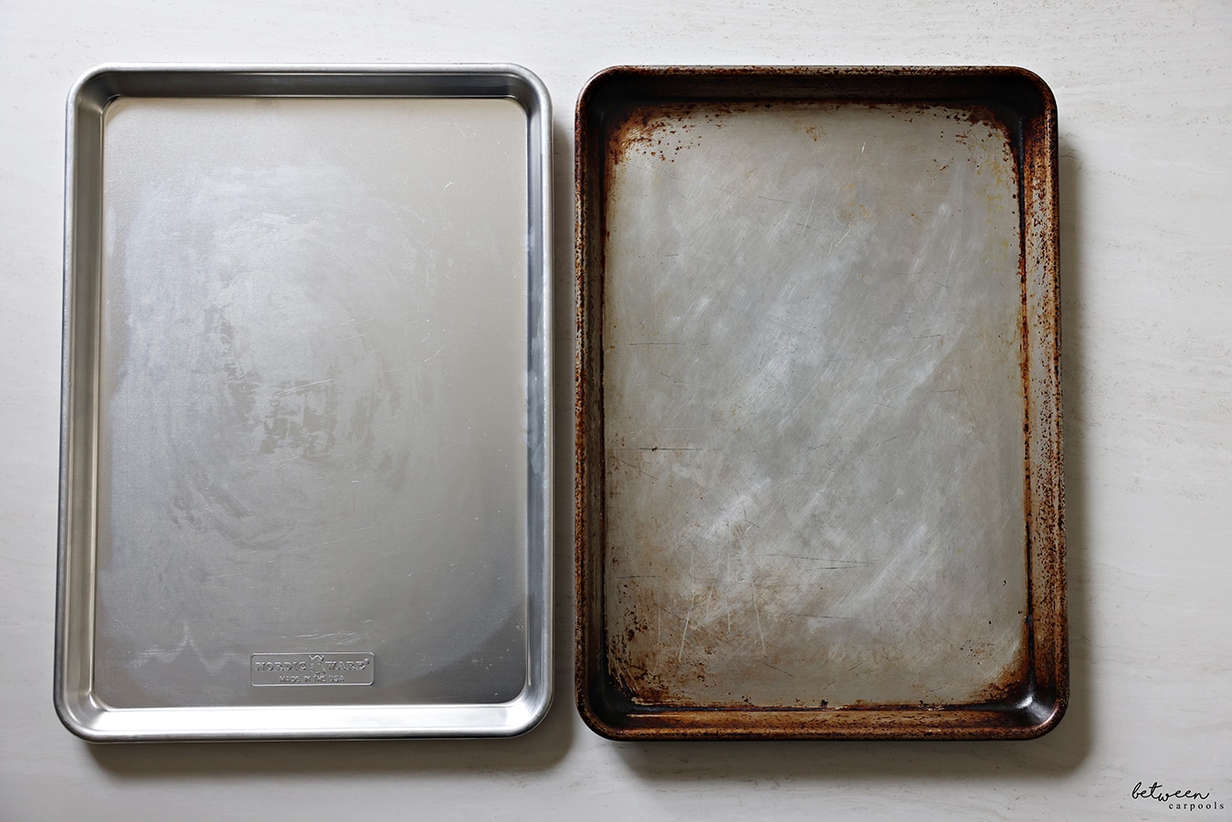 2 metal sheet pans, side by side - one used and one new