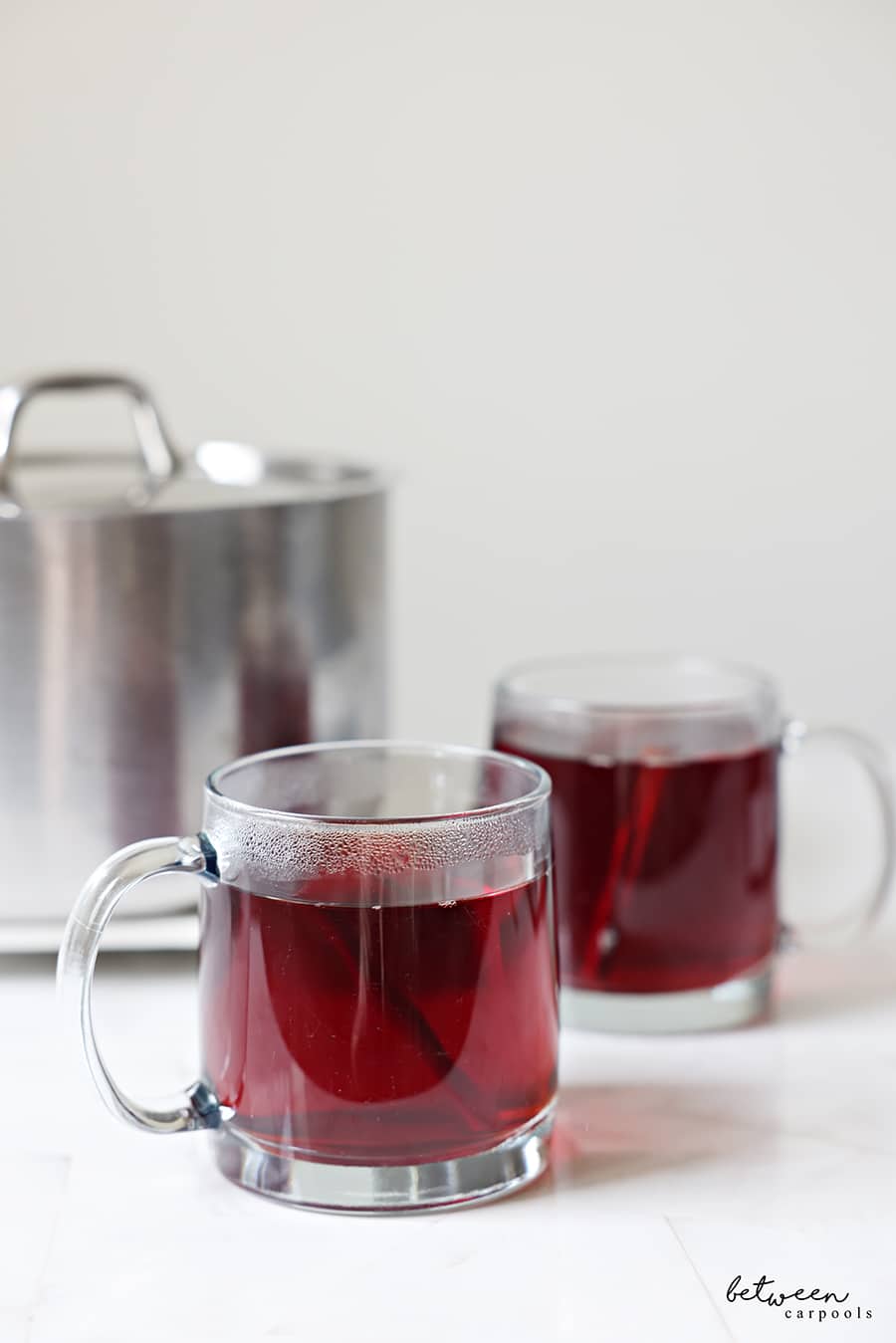Apple cider in 2 glass mugs.