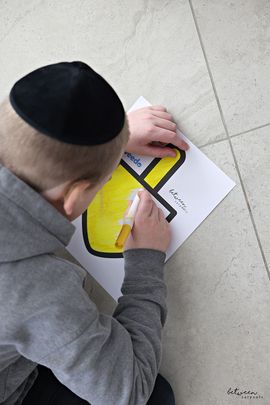 A boy coloring a between carpools x toveedo dreidel download.