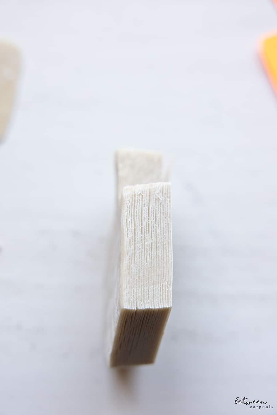 Stack of wonton wrappers in dreidel shape - on its side.
