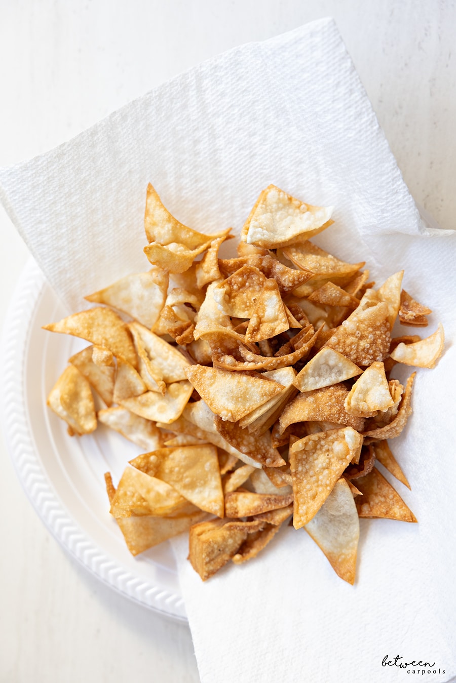 Leftover edges from dreidel shapes, fried, and on a paper towel lined plastic plate.