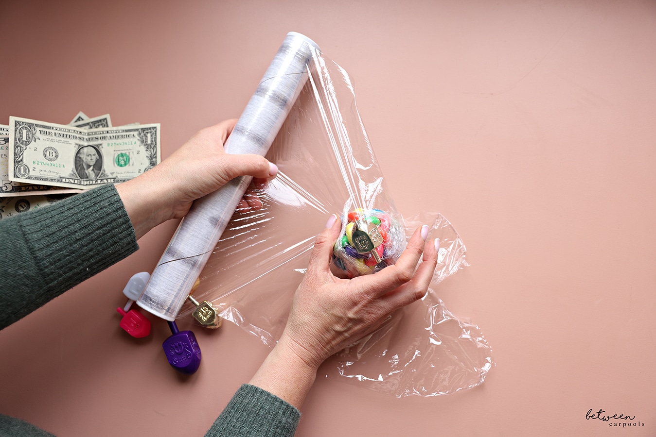A dreidel wrapped in Saran Wrap, around the small ball in Saran Wrap as the prize ball base.