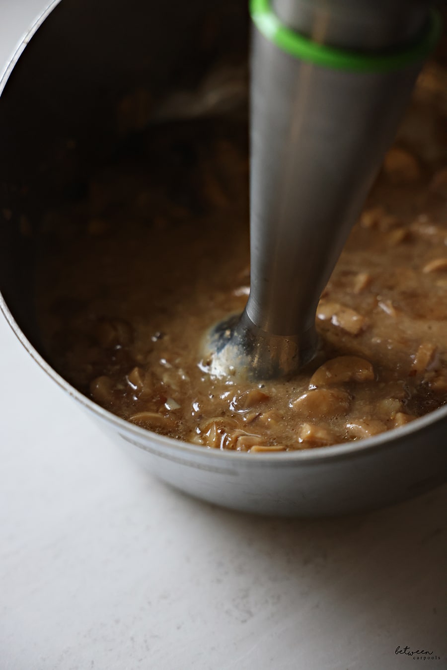Using an immersion blender to blend the chestnut mushroom soup a bit.