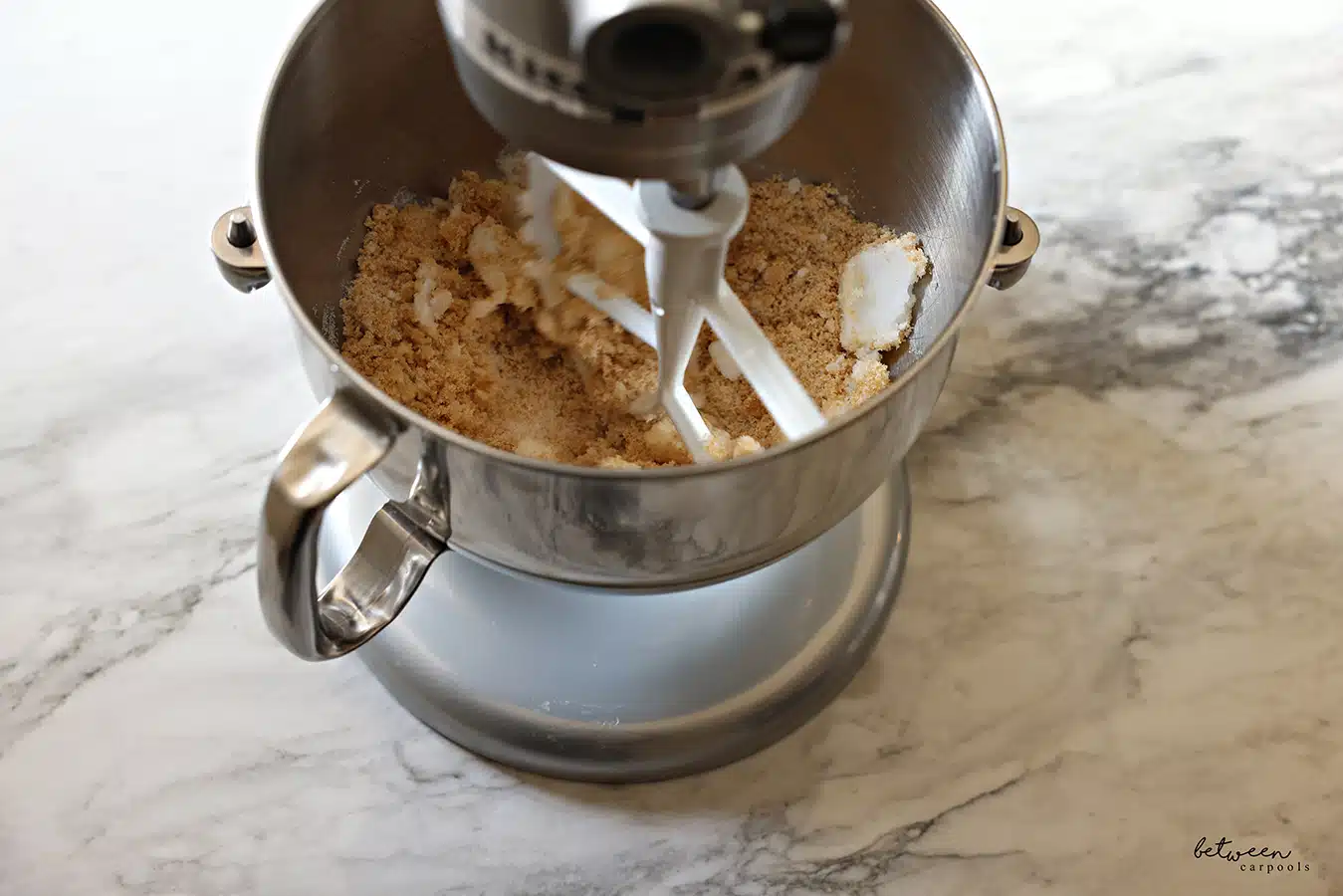 Creaming together the oil and sugars in the metal bowl of a Kitchen Aid mixer with the flat beater.