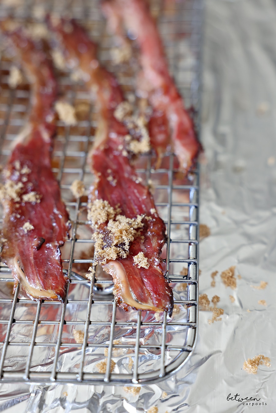 Facon baked with dark brown sugar on a cooling rack on a foil lined baking sheet.