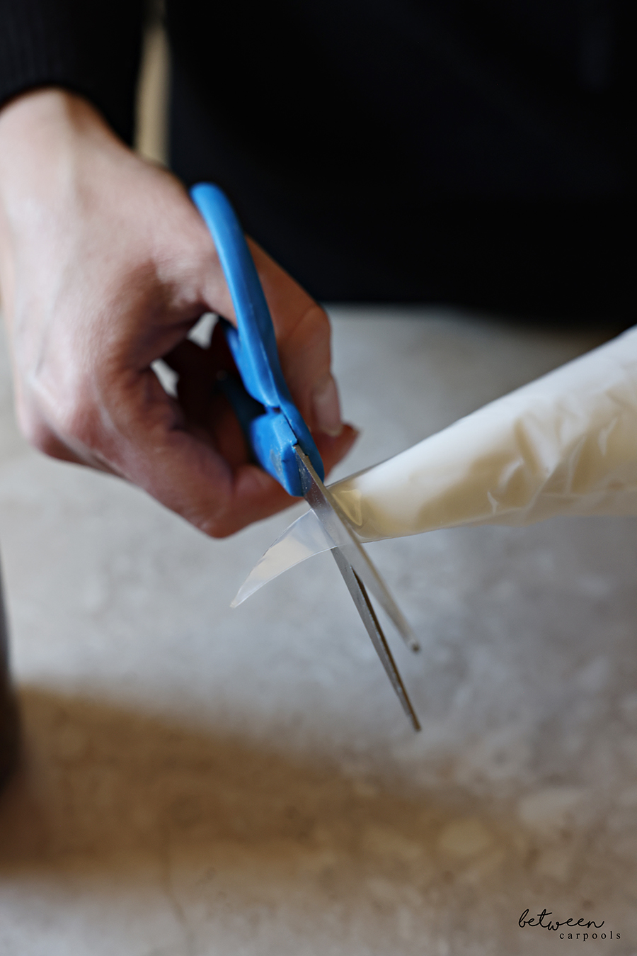 Cutting the tip of a piping bag filled with Dove body wash.