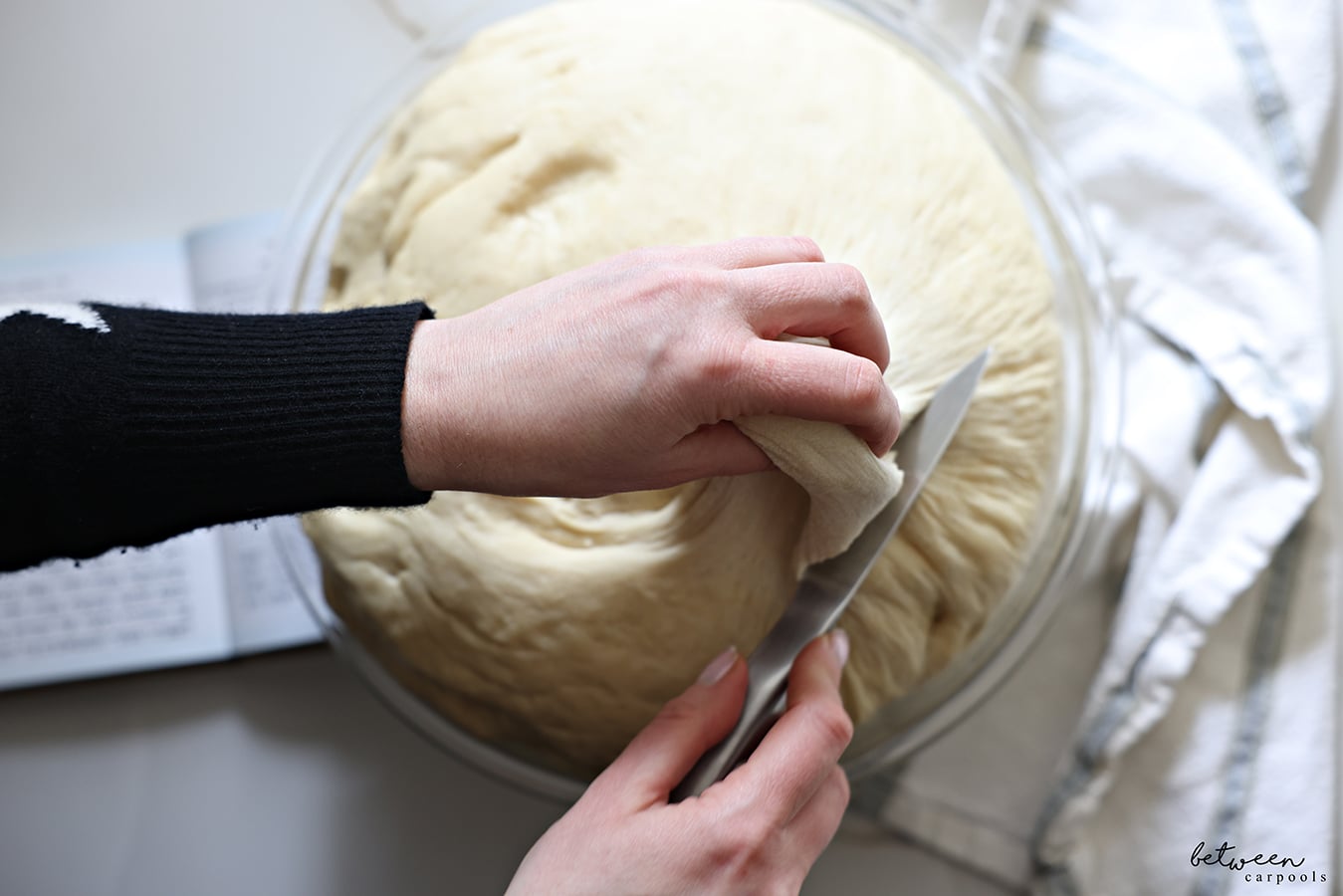 Taking challah from challah dough in a Pyrex glass mixing bowl.