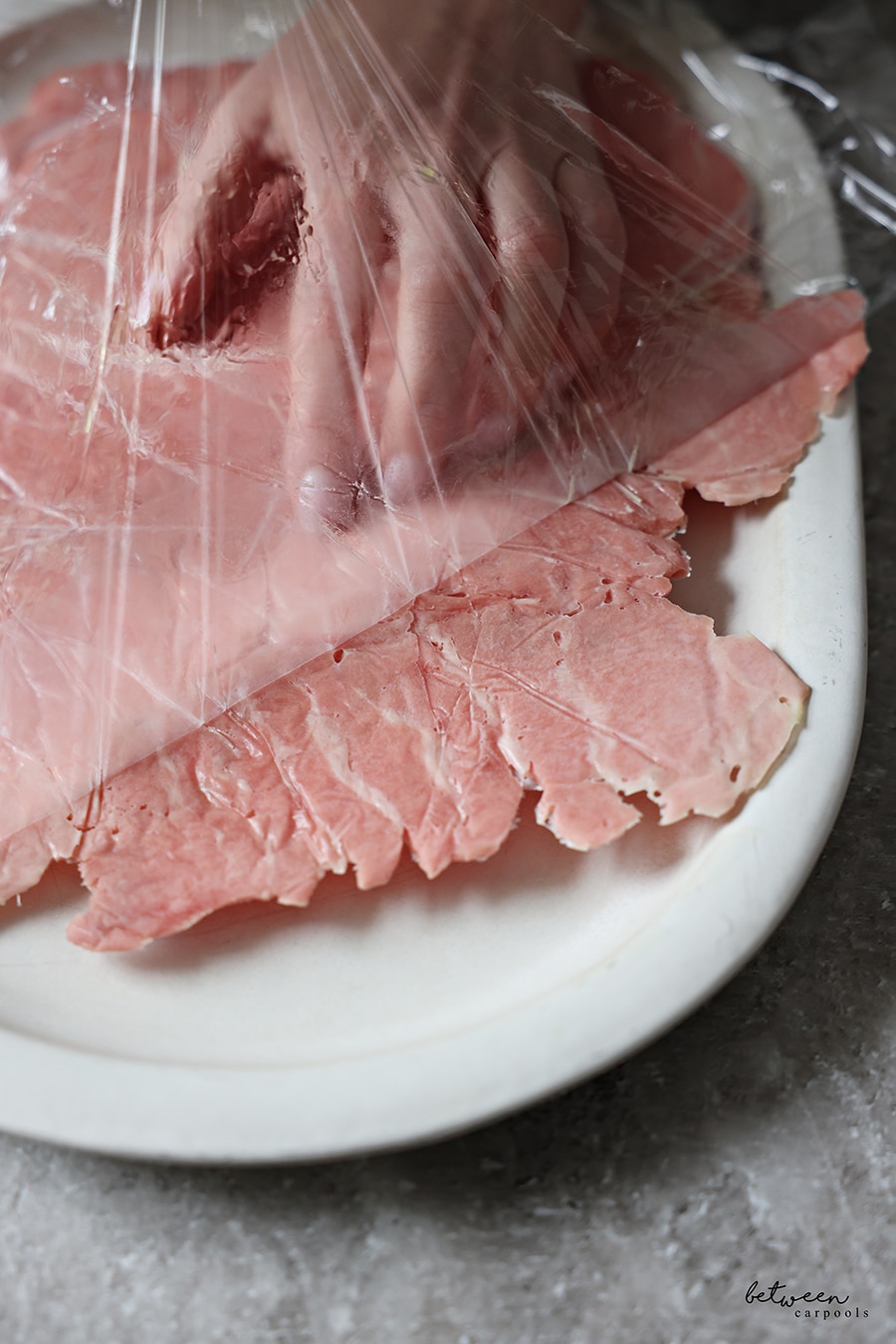 Tuna, pounded between 2 layers of plastic wrap and frozen then one layer removed, placed upside down on a serving platter, removing the other layer of plastic wrap to let the tuna thaw.
