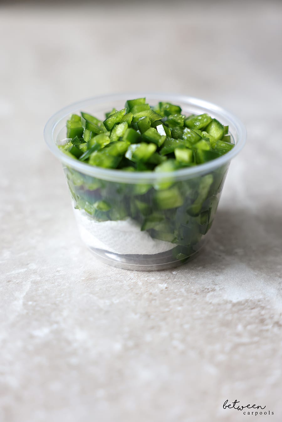 Diced jalapeño in a condiment cup with a bit of paper towel underneath.