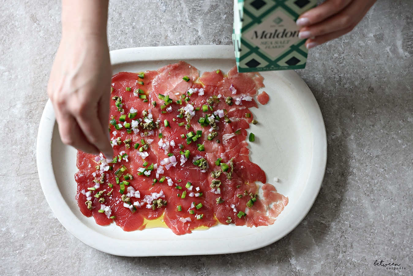 Finishing off tuna carpaccio with a bit of Maldon salt flakes.
