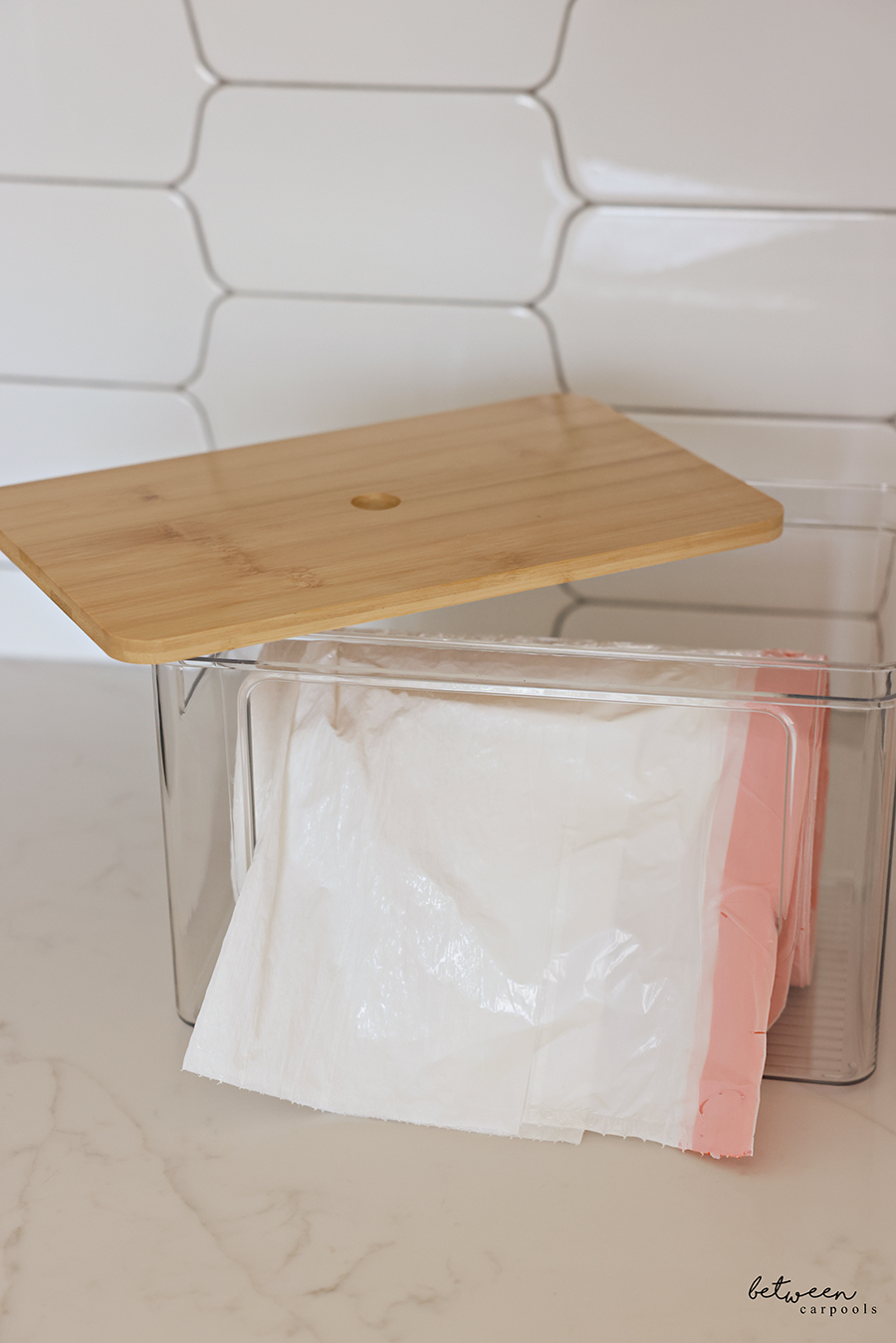 Garbage bag dispenser bin with a roll of garbage bags.