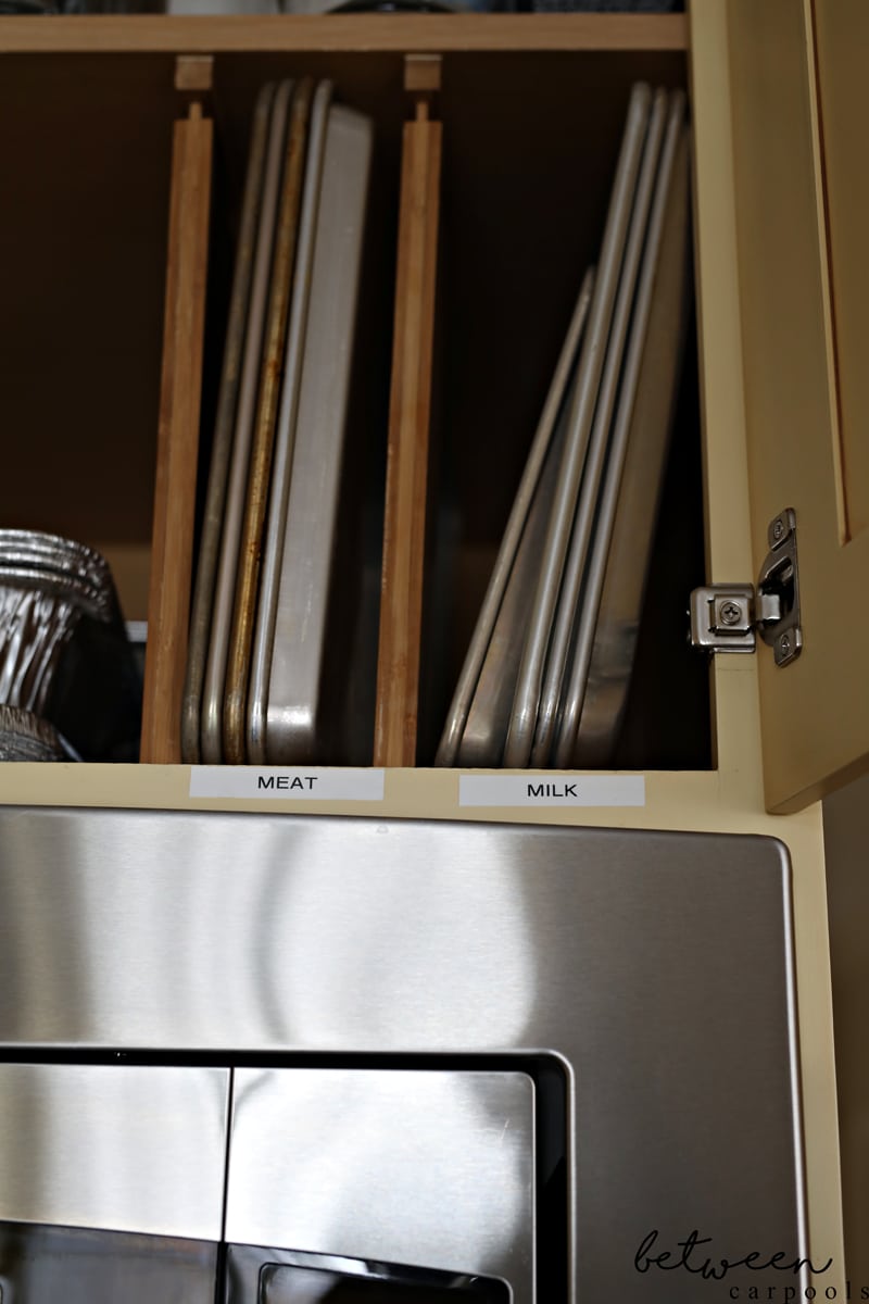 Top cabinet with drawer dividers installed vertically. Metal sheet pans stored between the dividers