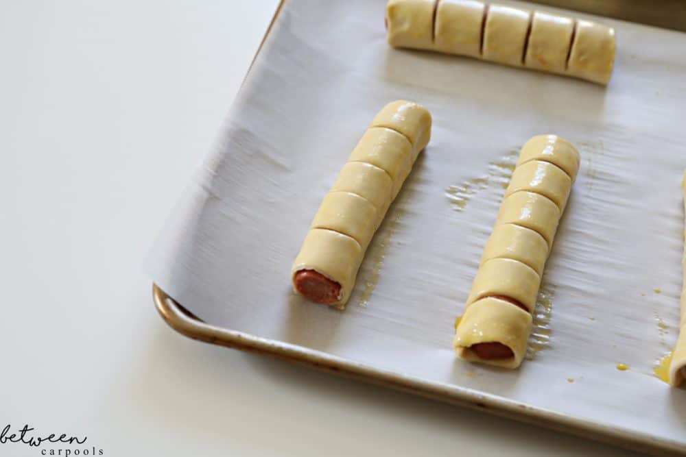 pull apart hot dogs on a parchment lined baking sheet ready to go into the oven