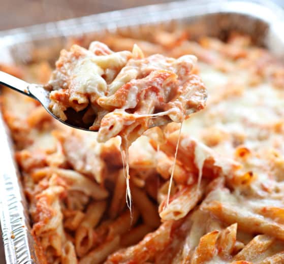 a spoonful of baked ziti from the pan, closeup