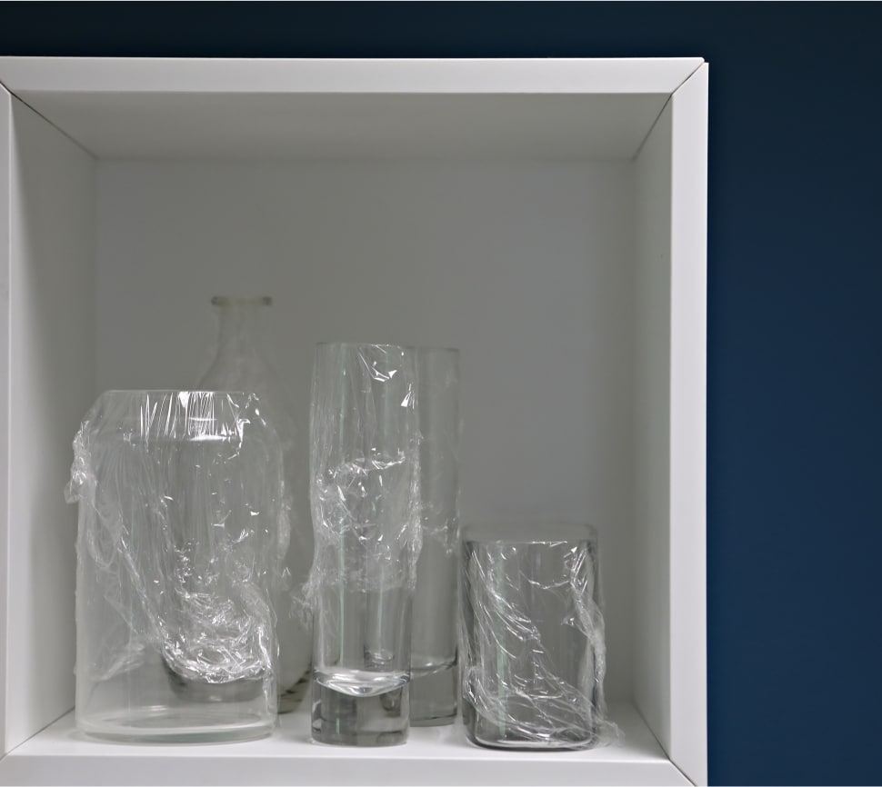 Vases on a shelf - tops covered with Saran Wrap