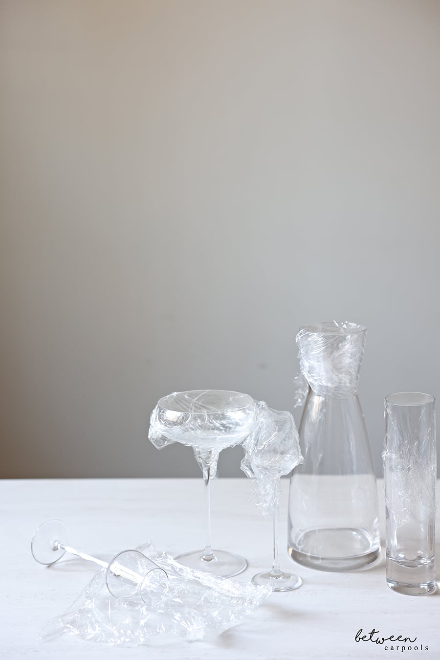 Stemware, a carafe and vase - tops covered with Saran Wrap