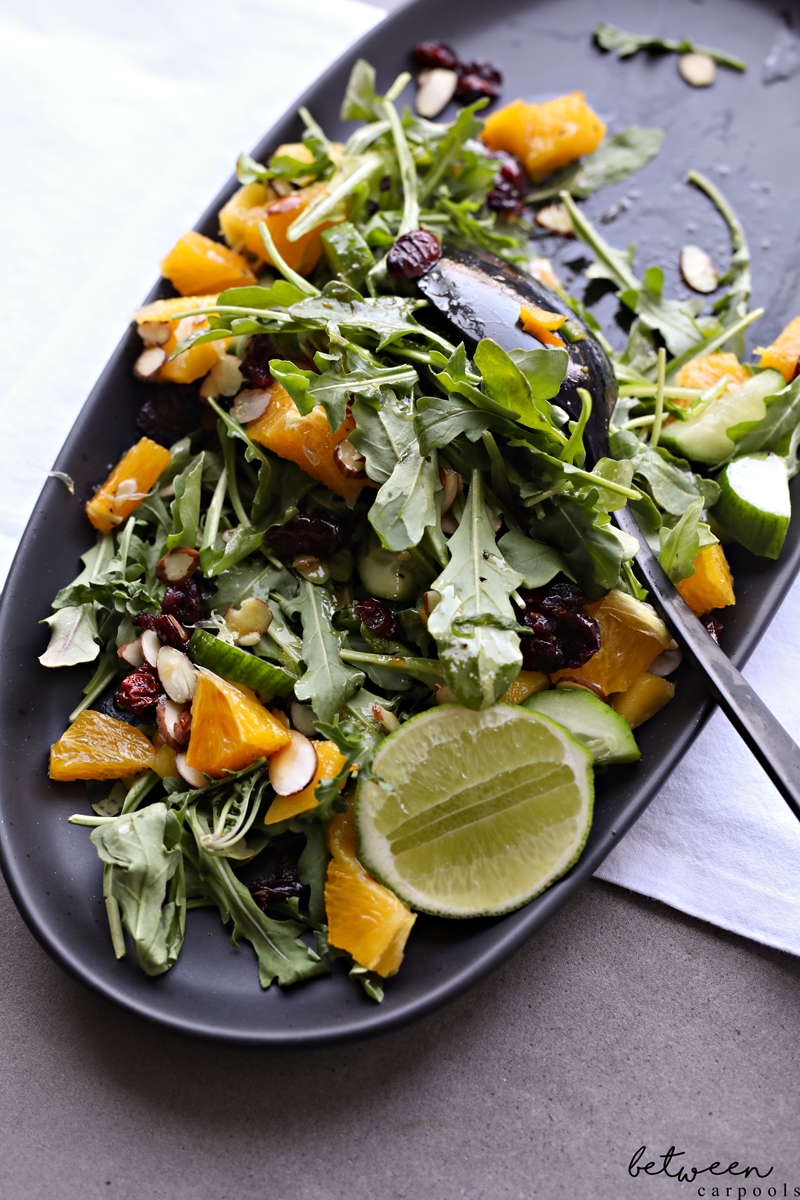 Close-up of Mango Salad with Silan and Lime Dressing on a black oval platter.