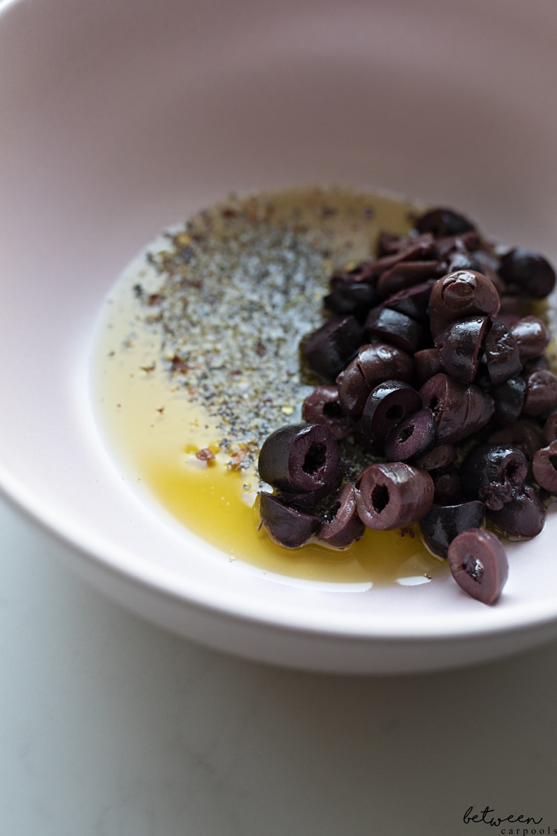 Mediterranean pasta salad dressing ingredients in a mixing bowl.