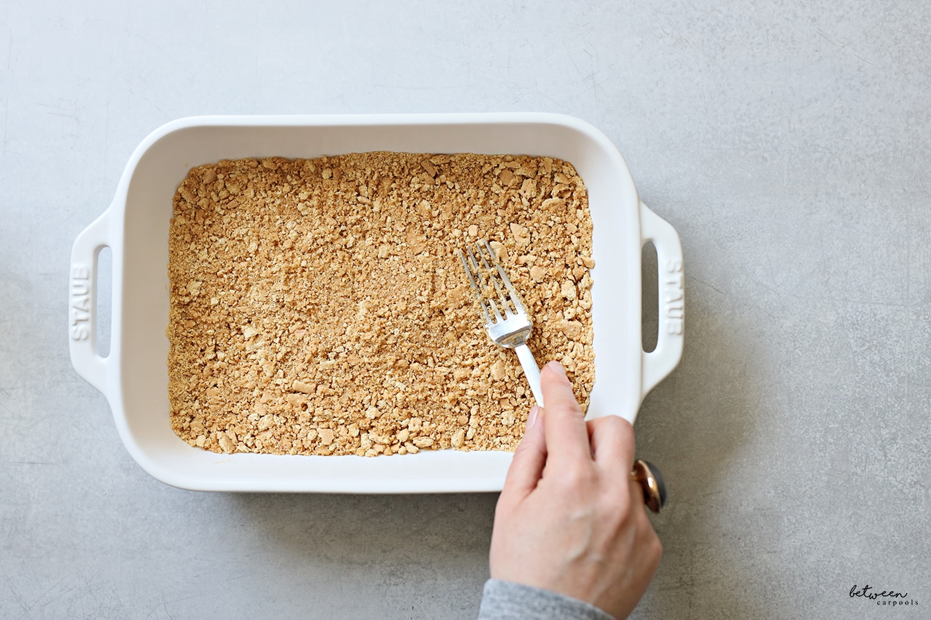 Crushed graham crackers in a 9x13 pan.