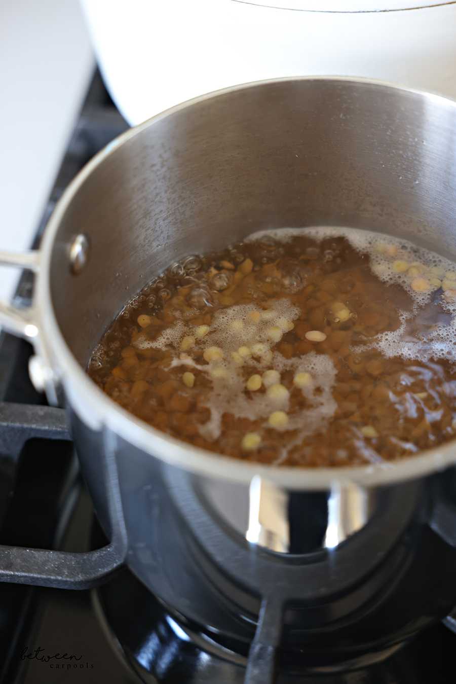 Boiling green lentils on the stovetop.
