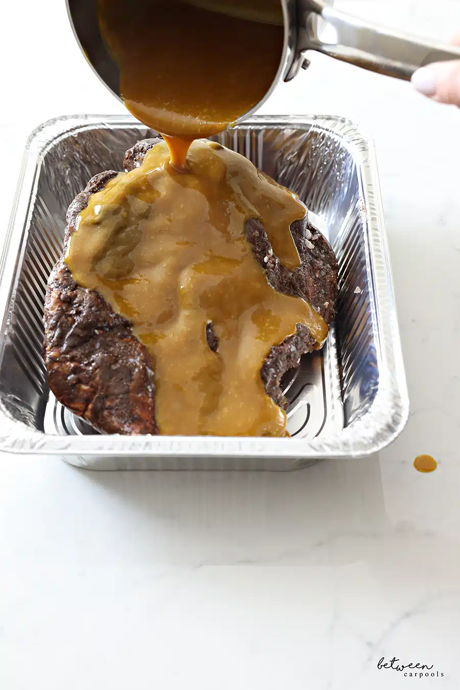 boiled brown sugar and mustard poured over a Navel Pastrami in a foil pan