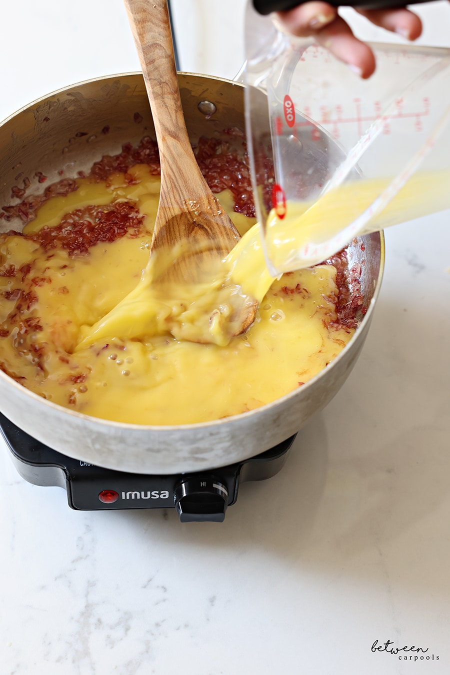 adding dissolved potato starch in orange juice to pot with sautéed red onion (sugar, ginger and lemon juice)