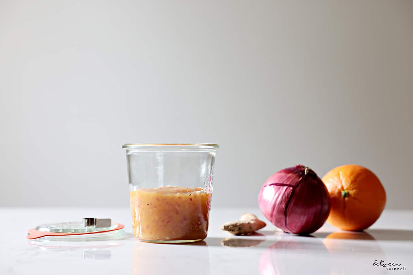 homemade duck sauce in a ball jar. ginger, a red onion and an orange