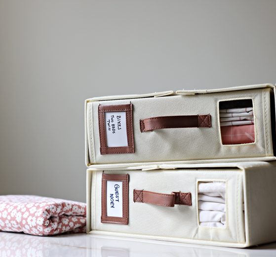 two bed sheet organizers, with a set of linen in each, labeled