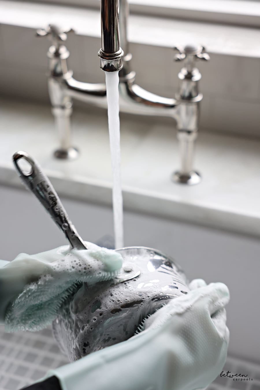 closeup of washing a pot with the gloves