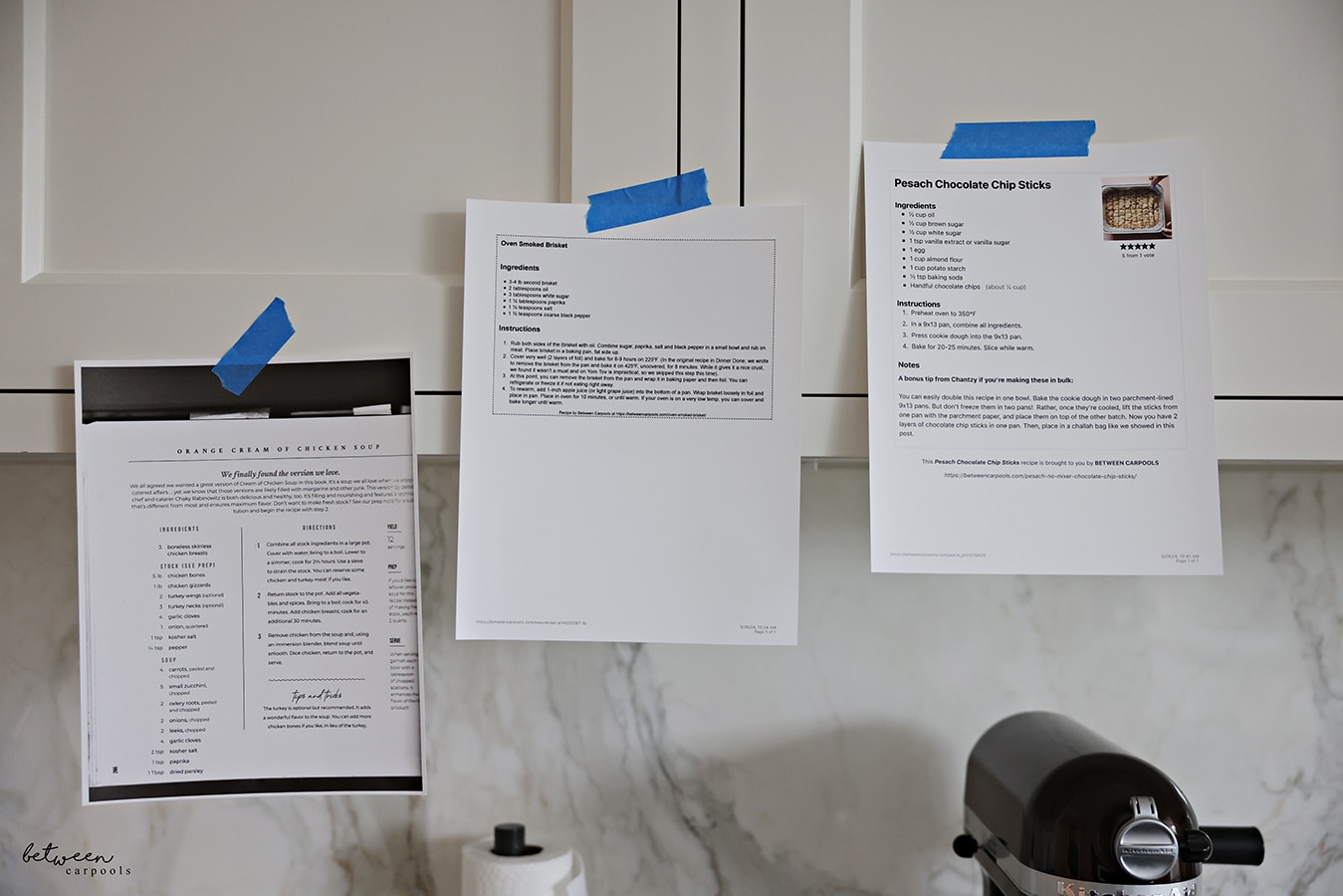 printed recipes taped to kitchen cabinets with painters tape