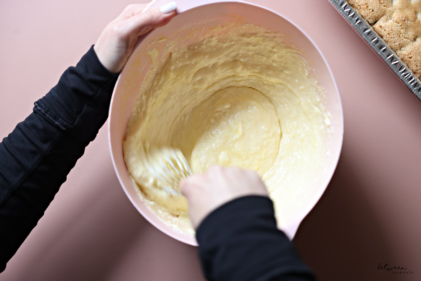 mixing cheesecake ingredients in a bowl by hand