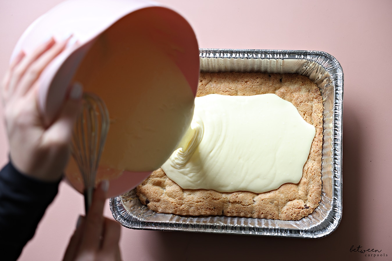 pouring cheesecake mixture over the cooled crust