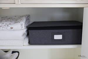 silver storage on shelf in linen closet