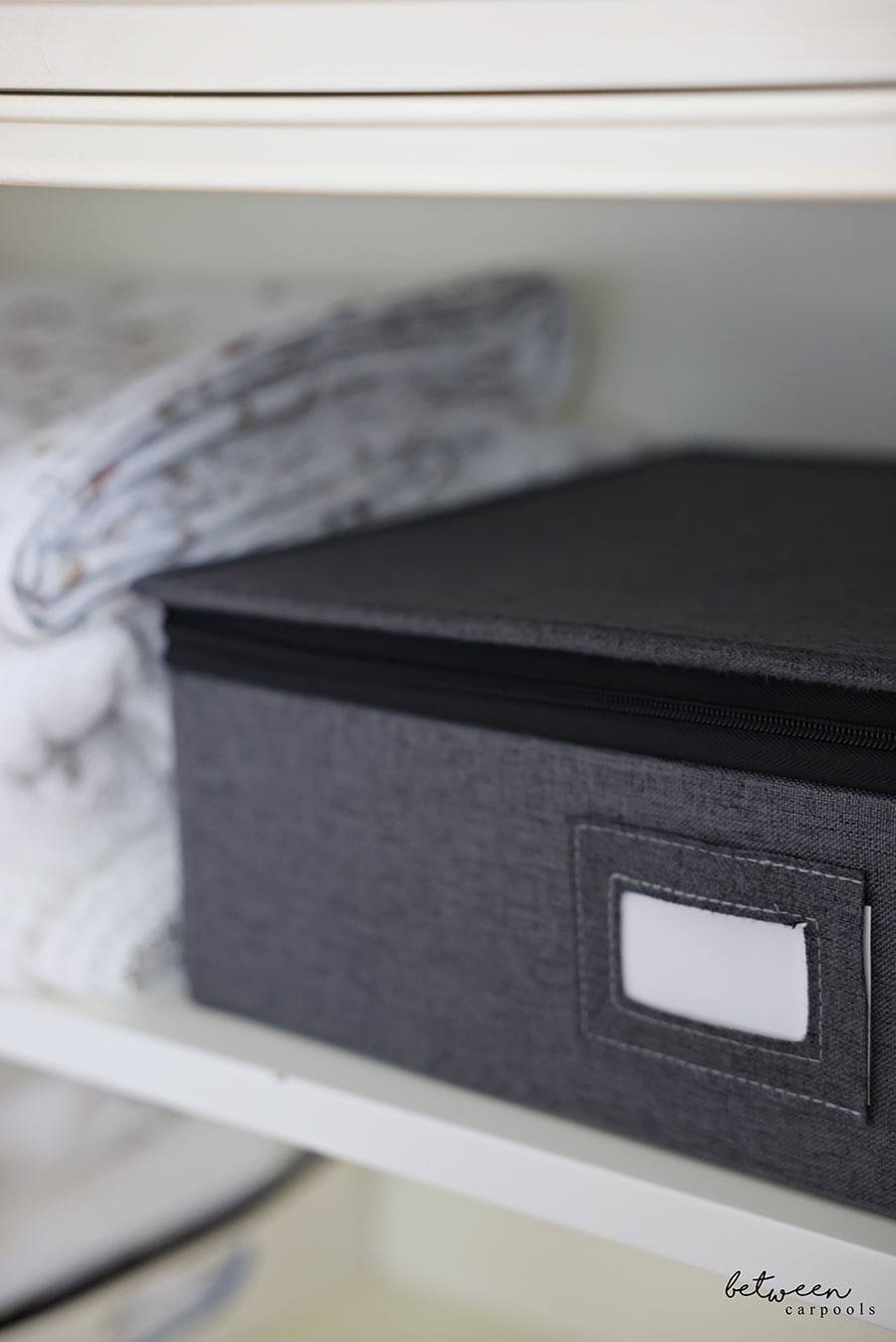 silver storage on shelf in linen closet