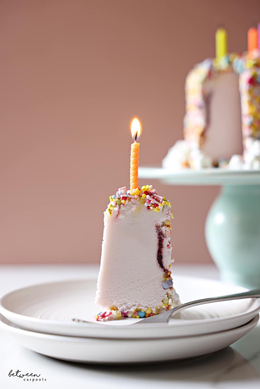 a slice of the pint of ice cream cake, on an individual plate with a candle
