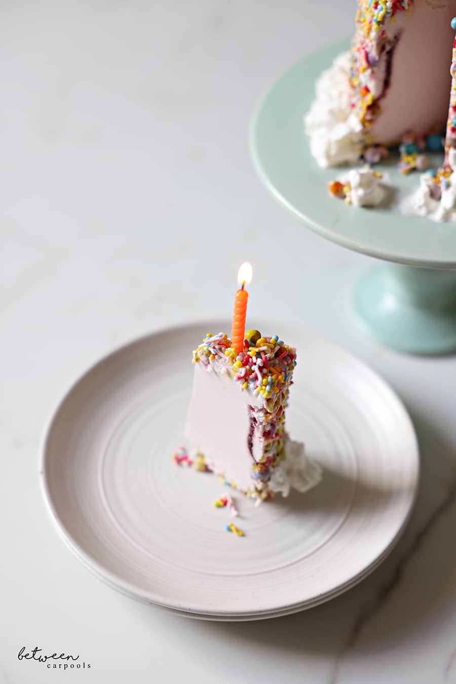 a slice of the pint of ice cream cake, on an individual plate with a candle