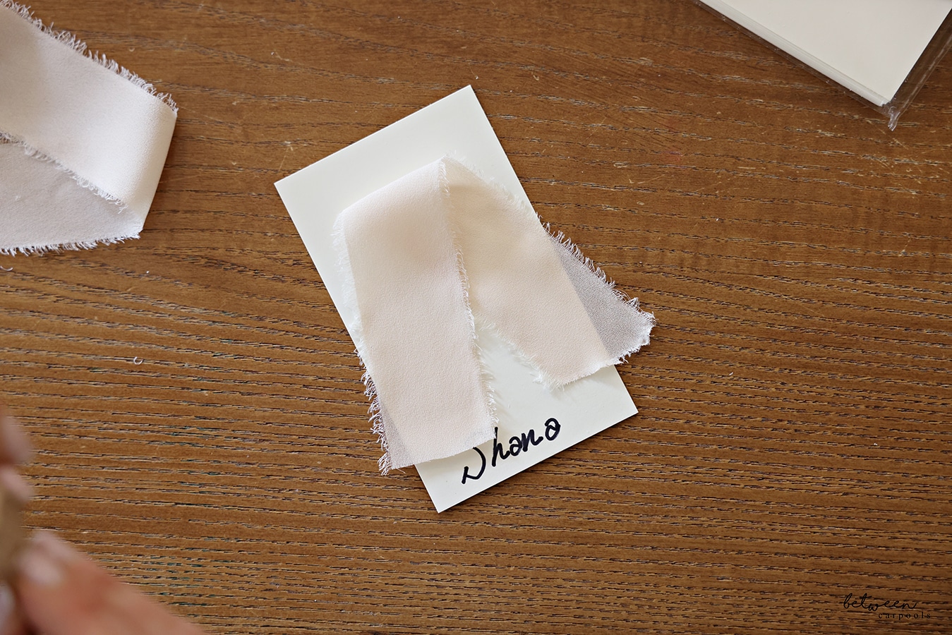 a piece of ribbon placed folded toward the top of the place card