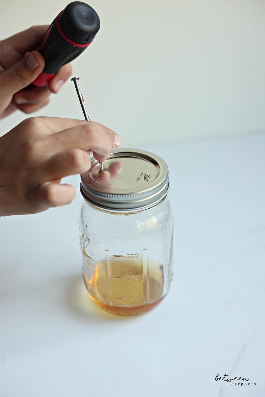 punching holes into the lid of a Ball jar