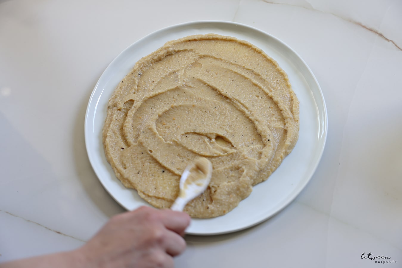 spreading creamy eggplant mixture on a plate